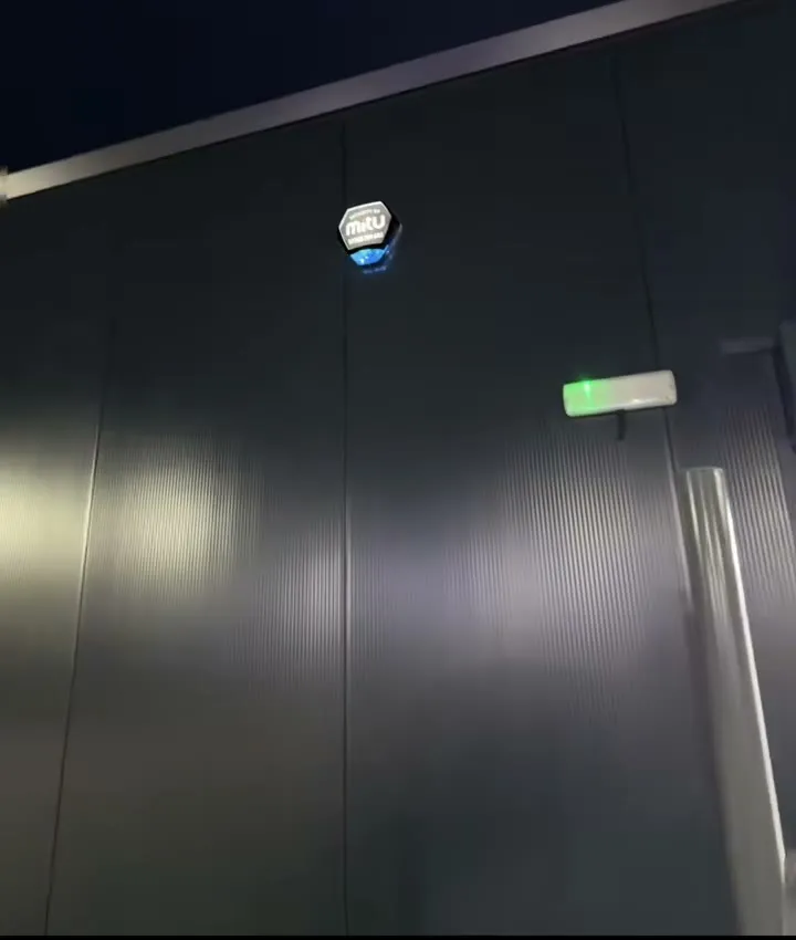 An alarm siren lit at night on the outside wall of a shop in Halifax