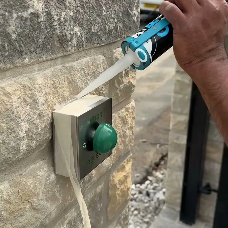 Sealing a gate exit button set into a stone pillar
